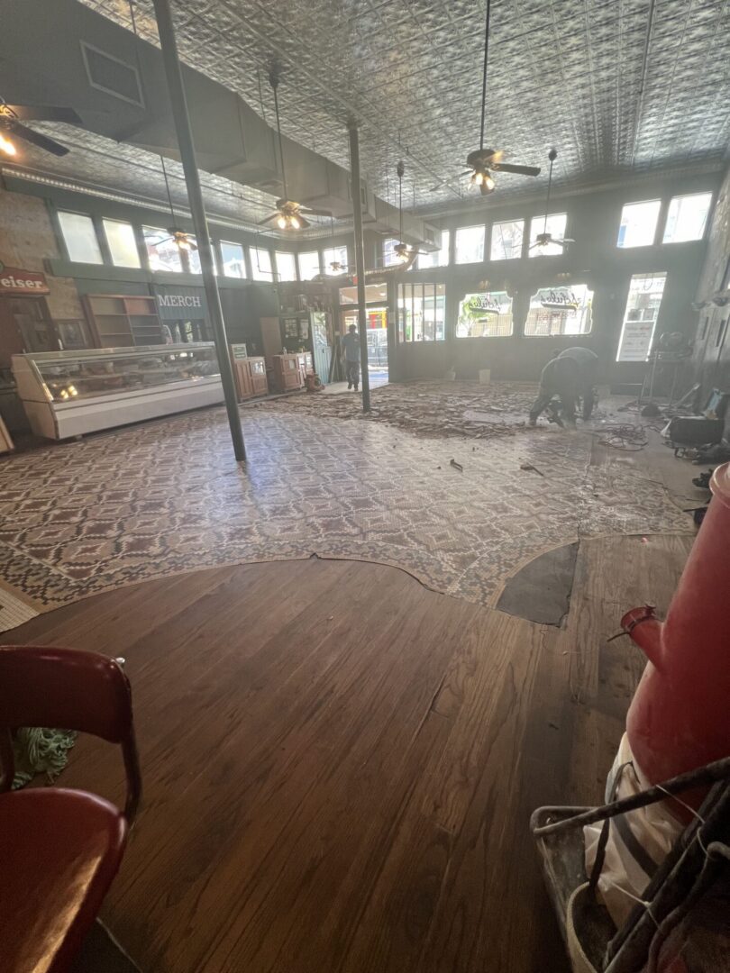 Construction workers prepare a space for Metallic Epoxy Flooring installation in a vintage-style interior.
