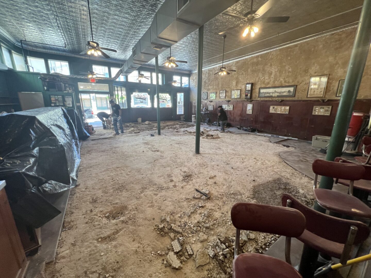 Construction workers prepare a space for Metallic Epoxy Flooring installation in a partially renovated interior.