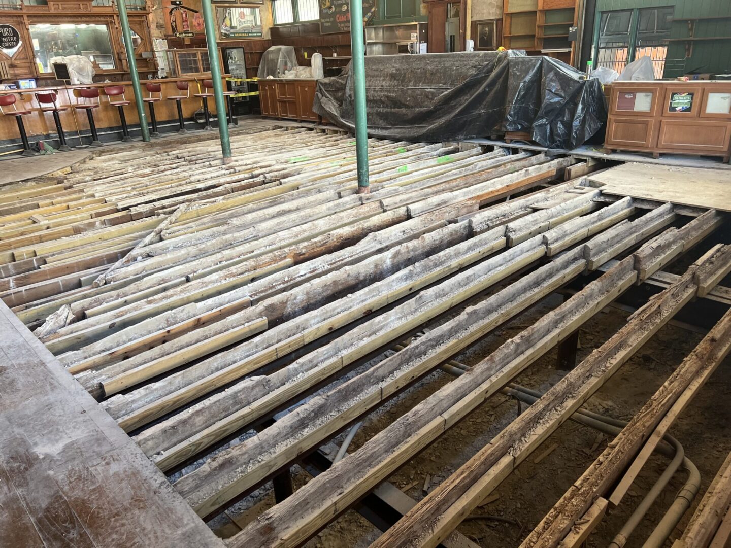 Exposed wooden beams and flooring in a construction area, preparing for Metallic Epoxy Flooring installation.