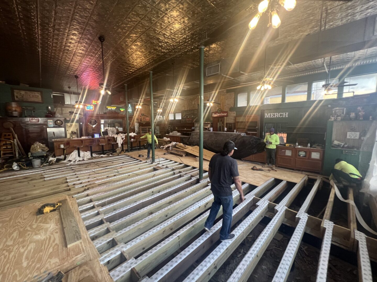 Construction workers install a new subfloor in a bar, preparing for Metallic Epoxy Flooring application.