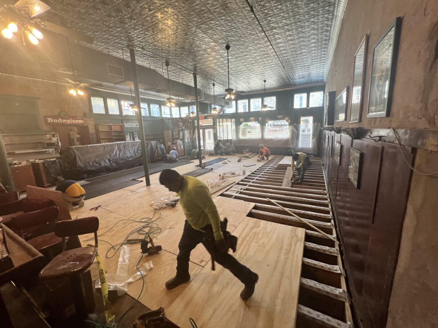 Bar under renovation with workers installing flooring