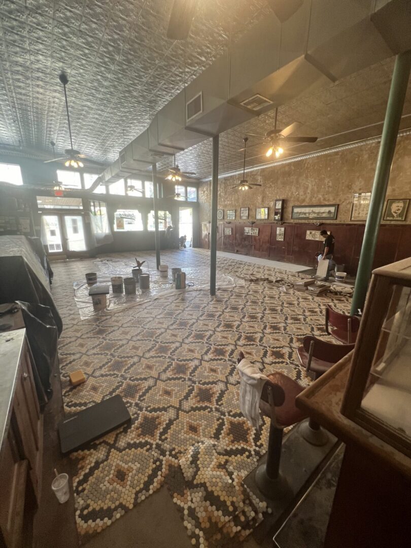 A spacious interior with a patterned floor installation in progress, showcasing Metallic Epoxy Flooring techniques.