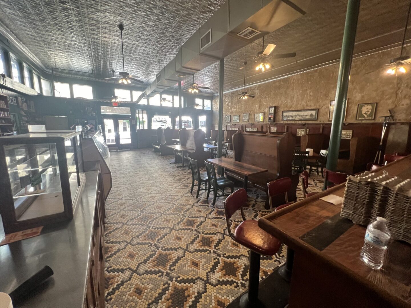 A spacious restaurant interior featuring patterned flooring and wooden furniture, showcasing potential for Metallic Epoxy Flooring.