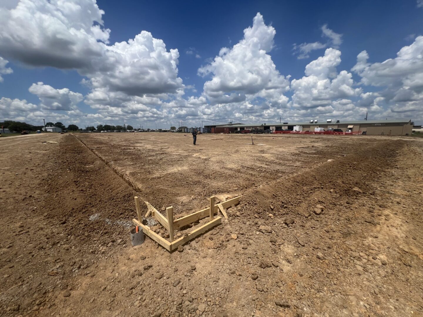 Construction site featuring steel framework and machinery, highlighting the future installation of Metallic Epoxy Flooring.