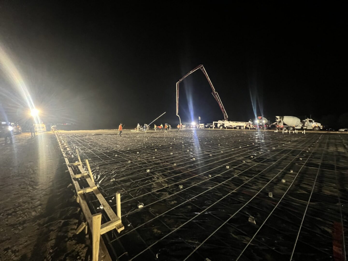 Construction site featuring steel framework and machinery, highlighting the future installation of Metallic Epoxy Flooring.