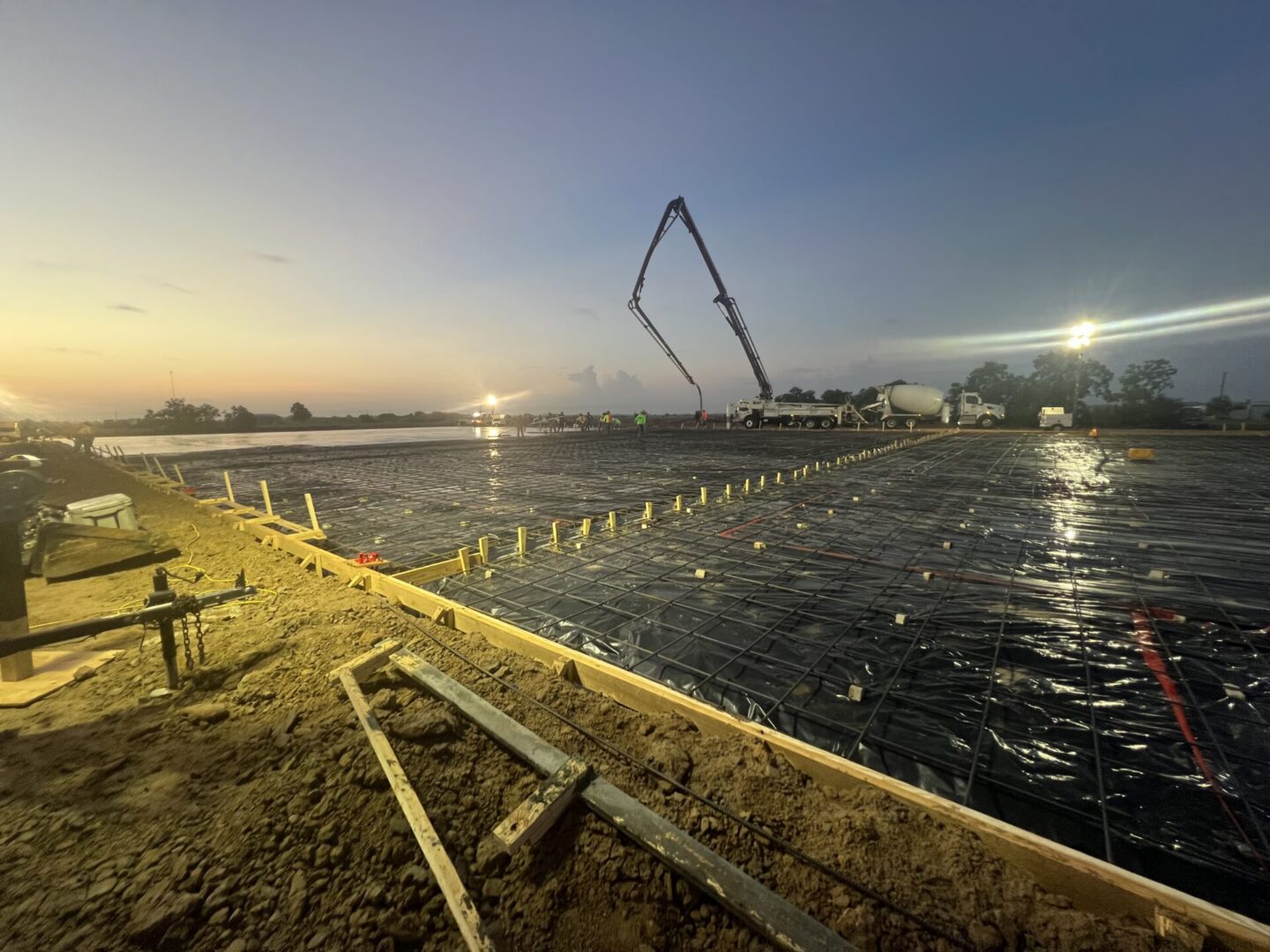 Construction site featuring steel framework and machinery, highlighting the future installation of Metallic Epoxy Flooring.