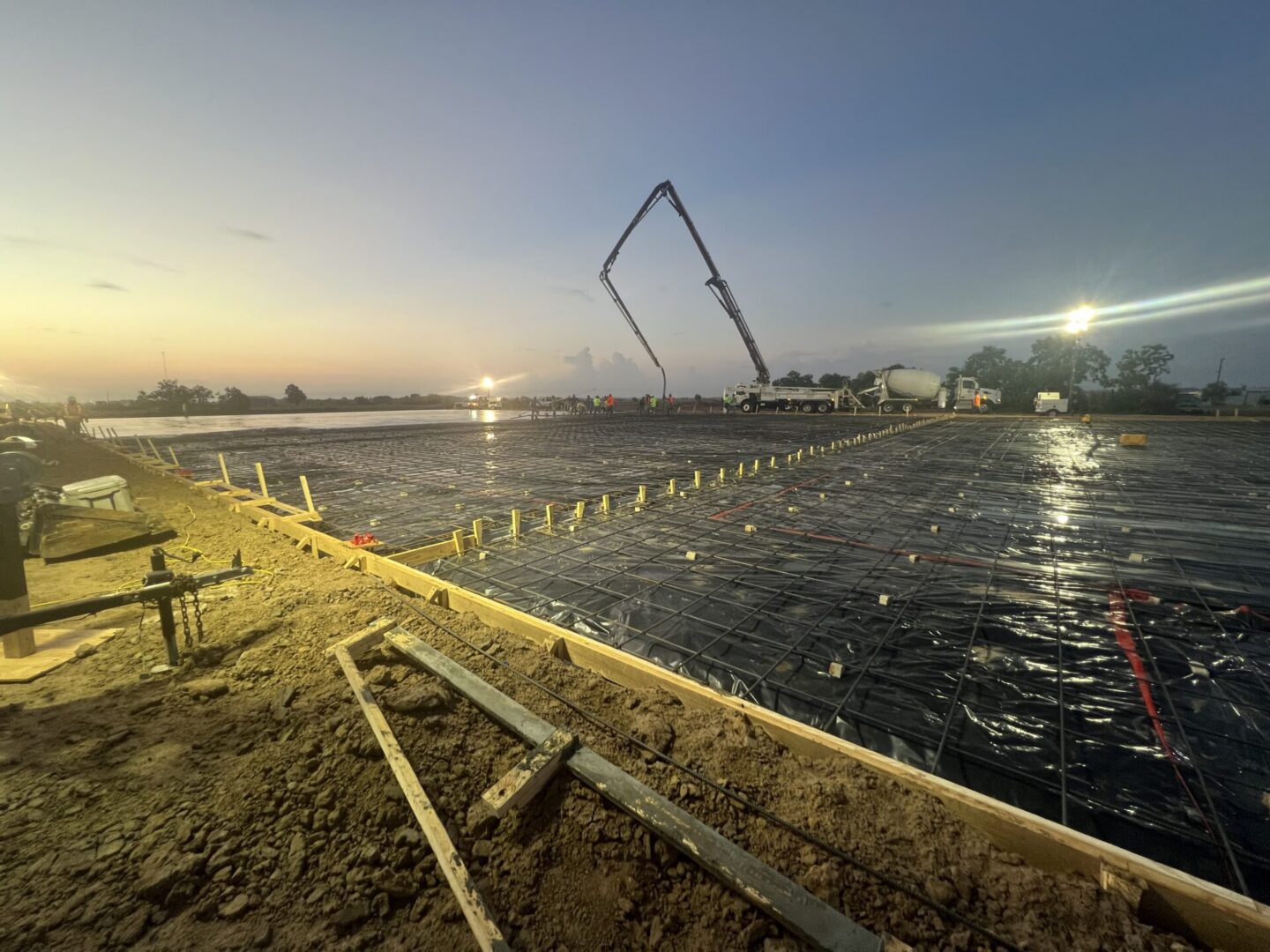 Construction site featuring steel framework and machinery, highlighting the future installation of Metallic Epoxy Flooring.