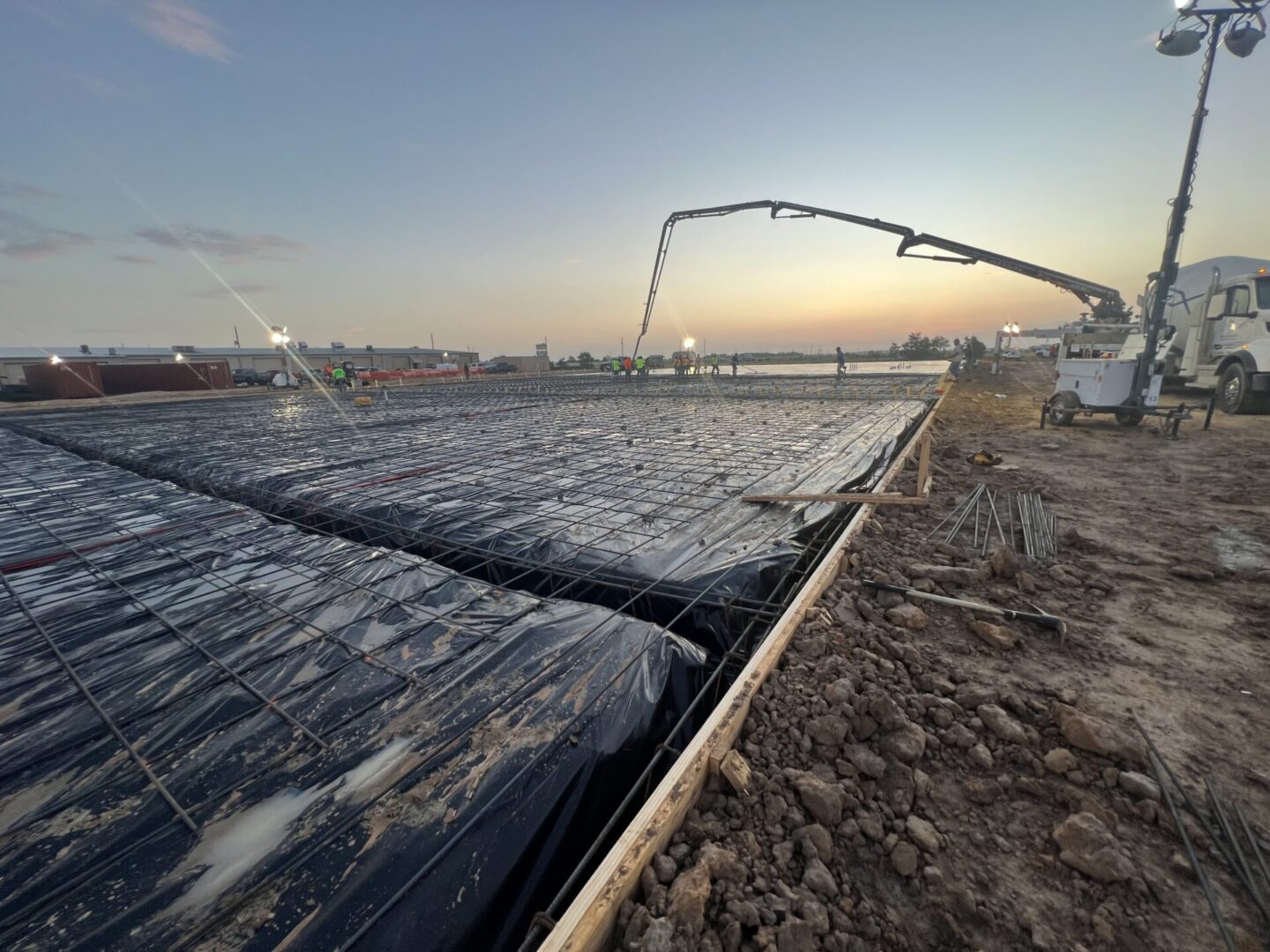 Construction site featuring steel framework and machinery, highlighting the future installation of Metallic Epoxy Flooring.