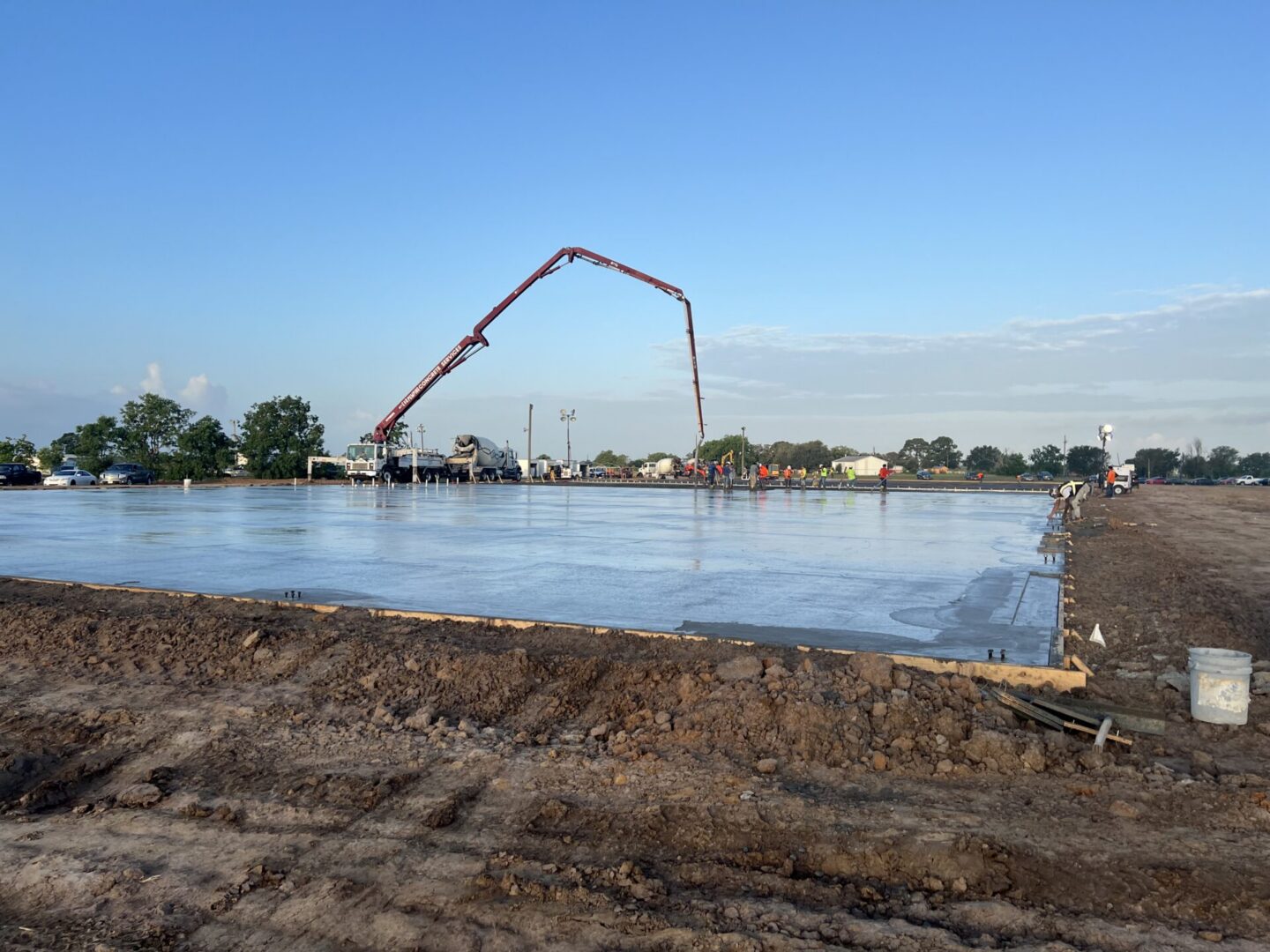 Construction site featuring steel framework and machinery, highlighting the future installation of Metallic Epoxy Flooring.