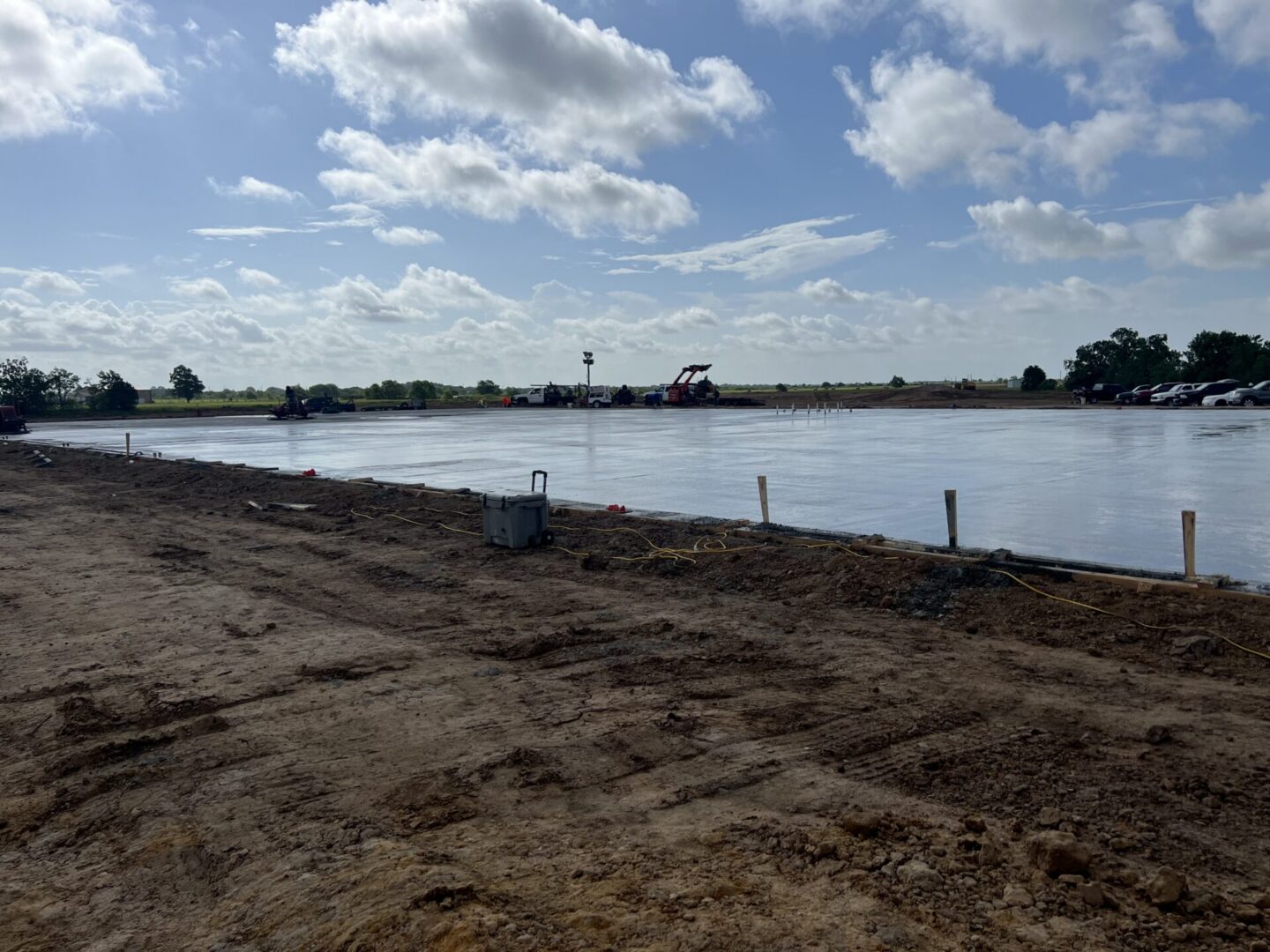 Construction site featuring freshly poured concrete, preparing for Metallic Epoxy Flooring installation under a clear sky.