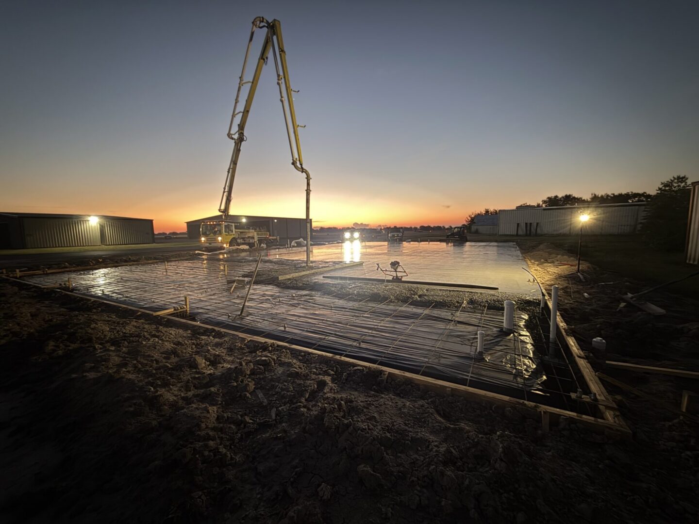 Construction site featuring steel framework and machinery, highlighting the future installation of Metallic Epoxy Flooring.
