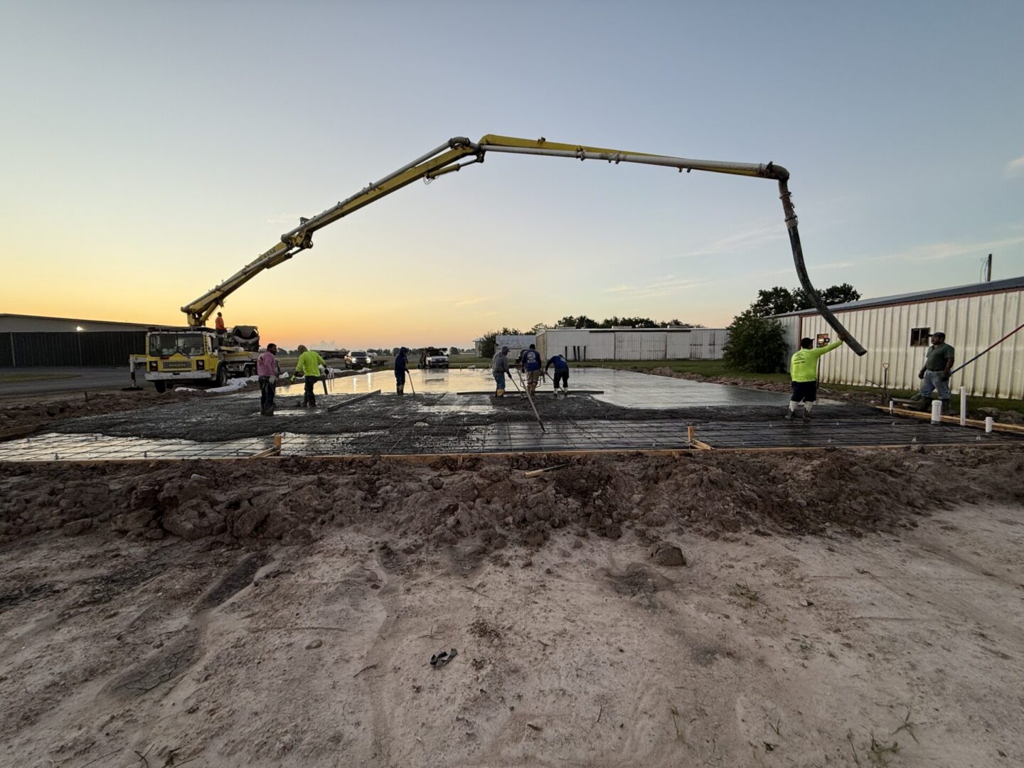 Construction site featuring steel framework and machinery, highlighting the future installation of Metallic Epoxy Flooring.