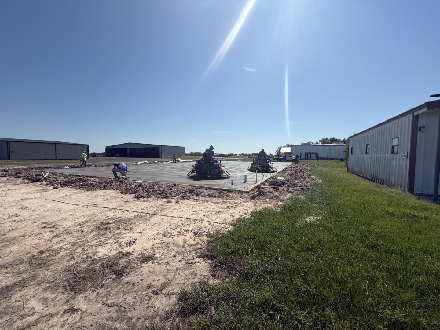 Construction site featuring steel framework and machinery, highlighting the future installation of Metallic Epoxy Flooring.
