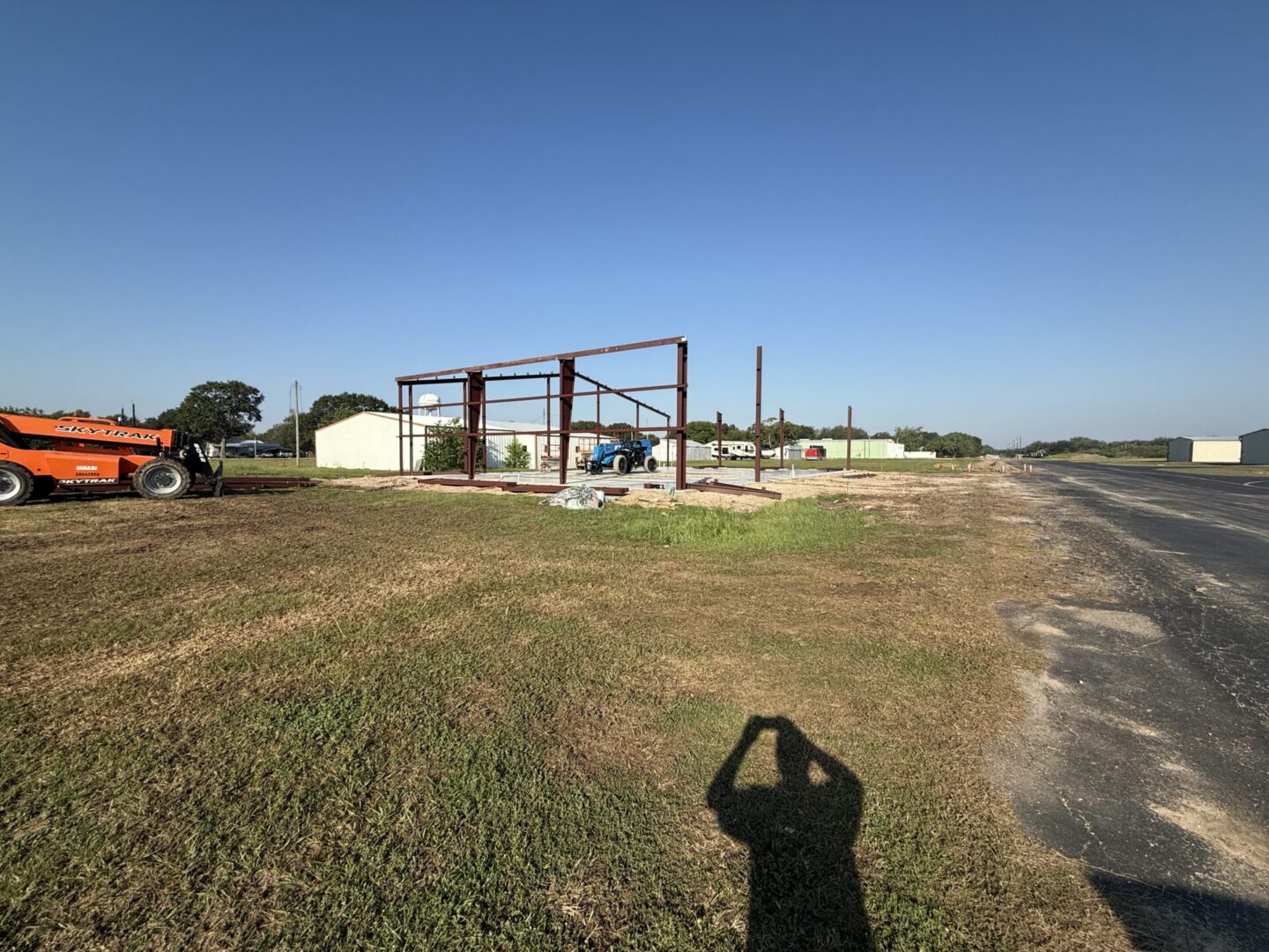Construction site featuring steel framework and machinery, highlighting the future installation of Metallic Epoxy Flooring.
