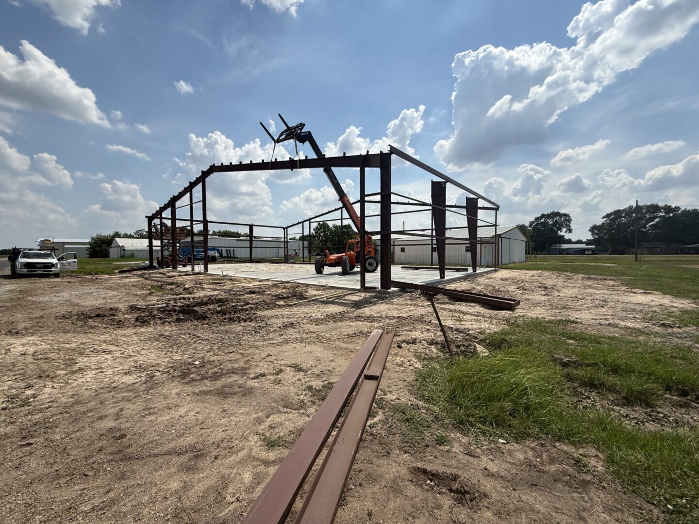 Construction site featuring steel framework and machinery, highlighting the future installation of Metallic Epoxy Flooring.