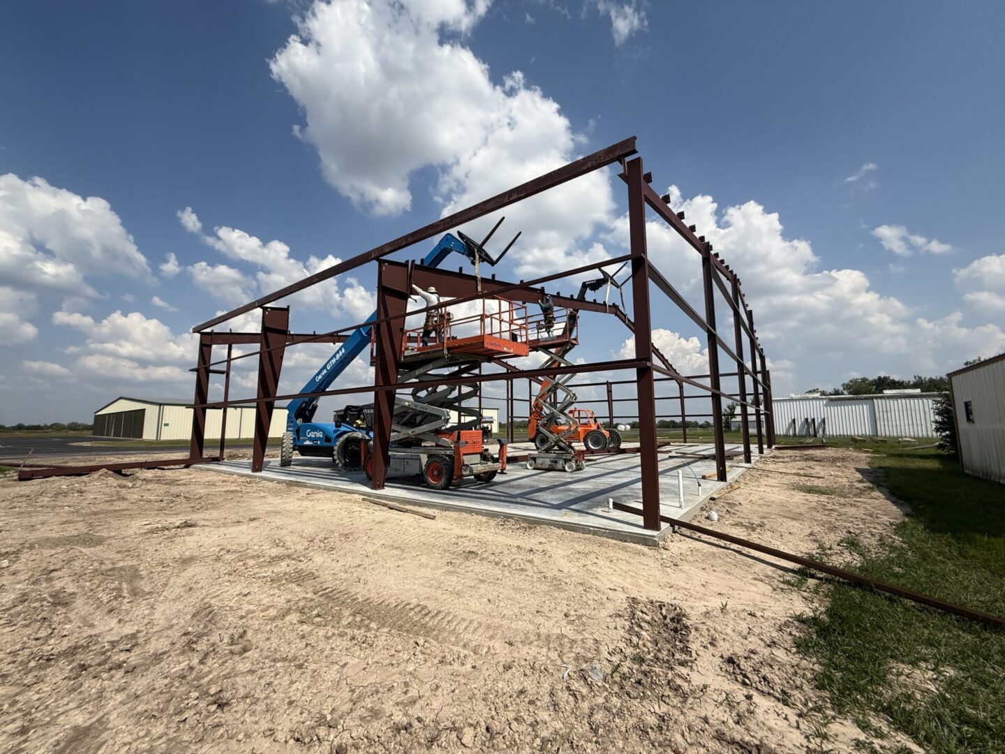 Construction site featuring steel framework and machinery, highlighting the future installation of Metallic Epoxy Flooring.