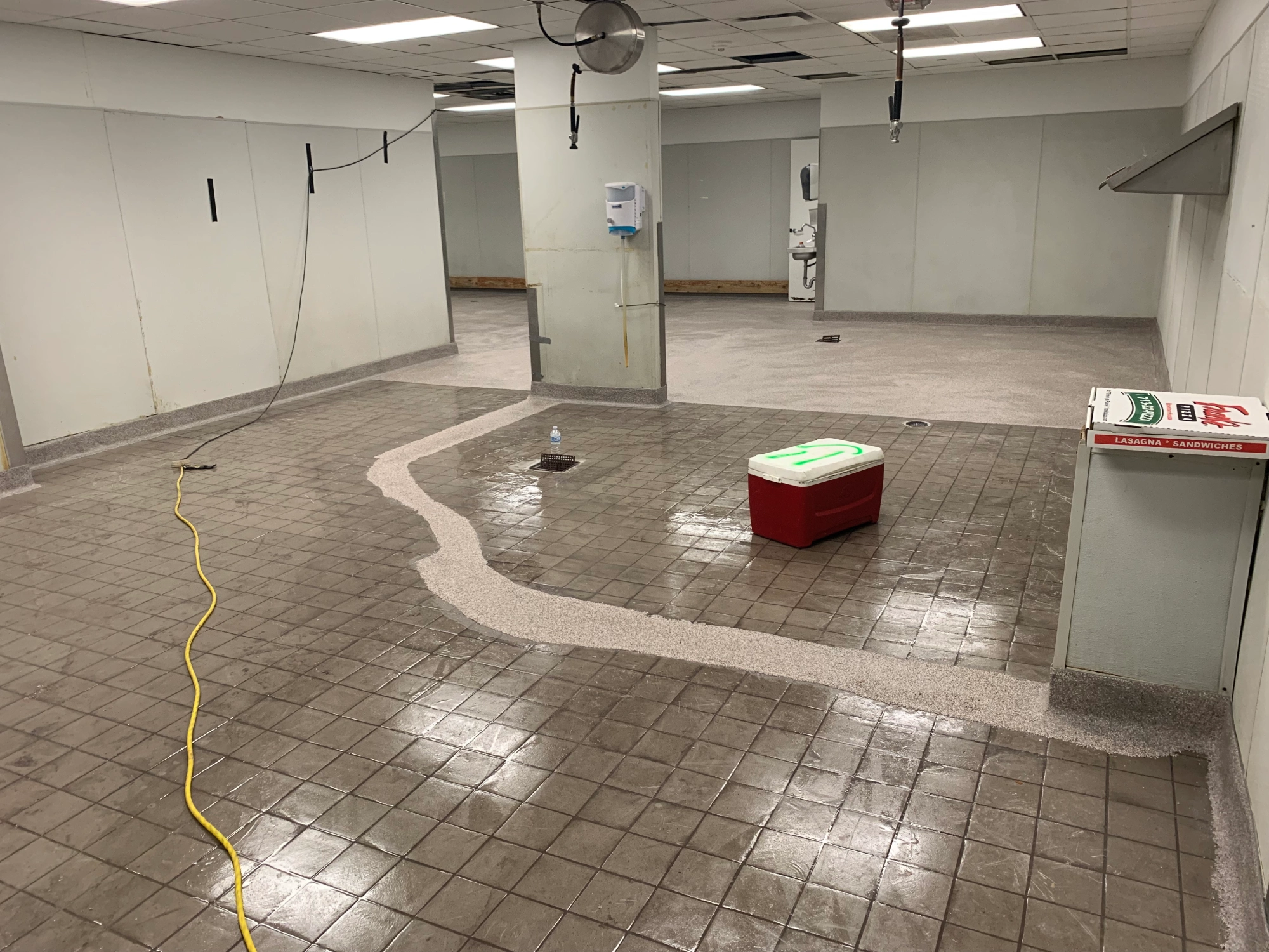 Empty room with tiled floor and cooler.